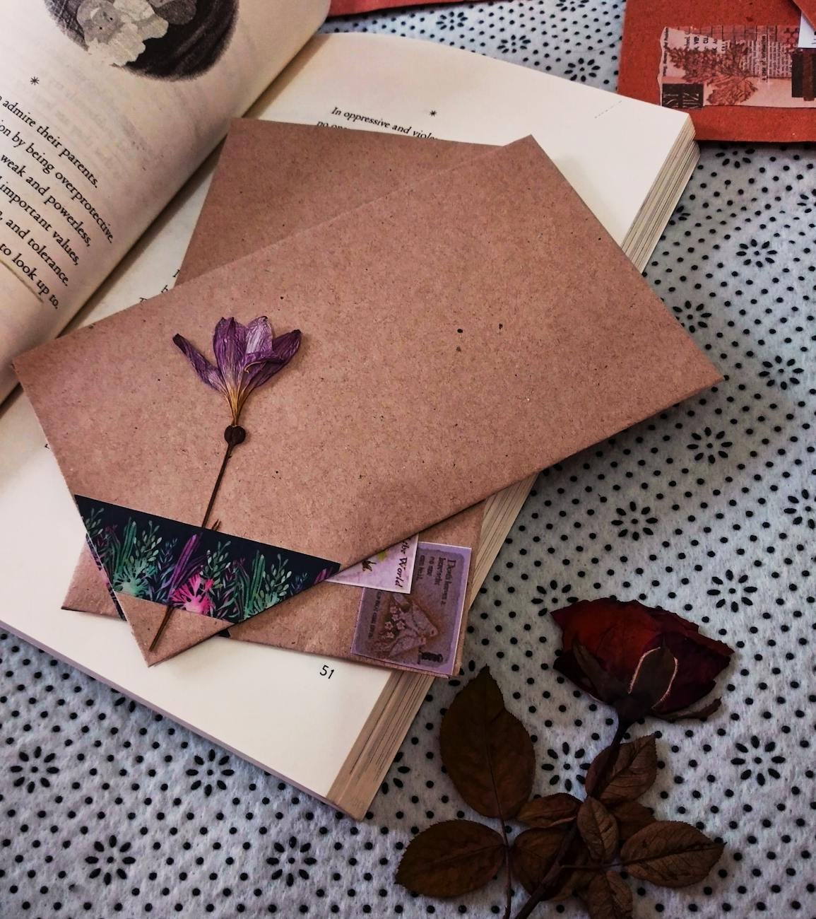 brown envelopes with flowers and stickers inside open book