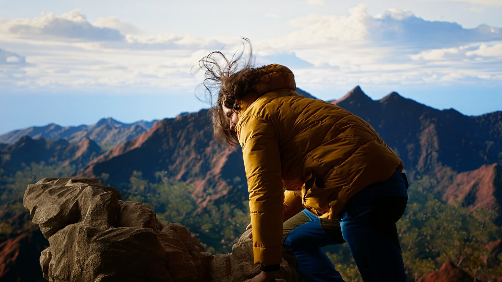 Clumsy hiker tripping and falling off of a mountain peak cliff, leading to an accident due to lack of attention. Inconsiderate unprepared traveler stumbles on unstable terrain. Camera B.